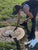 Bethany Shorb printing manhole garments outside, inking manhole printing plate