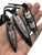 Orthoceras Fossil Pendants, black. Deer leather knotted cord. Hand for scale