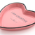 Heart-shaped pink plate with black rim and text 'I AM CREATIVE I CREATE PROBLEMS EVERYDAY' on a white background.