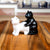 Black and white ceramic cat figurines in a suggestive position on a wooden table.