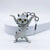 A white and gray tabby cat keychain figurine with yellow eyes and black stripes, posed with its paws raised, attached to a silver metal key ring on a clean white background.