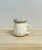White mug with a mushroom-shaped lid on a wooden surface