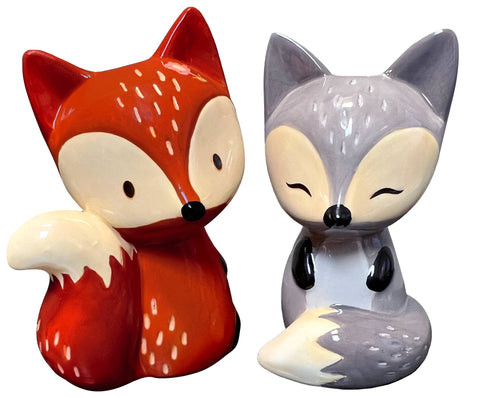 Two fox-shaped salt and pepper shakers, one red and one gray, on a white background.