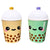 Two cute ceramic boba tea cup containers with smiling faces, one in pale yellow and one in mint green, both with brown boba and white lids.
