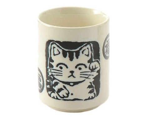 Tea cup with a lucky cat design with traditional Japanese stamp imprinting and japanese characters on a white background. 