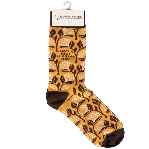 Sock with leaf design on a white background. Text  on socks reads "Have a nice fucking day."