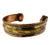 A vintage brass cuff bracelet featuring engraved animal motifs and decorative rope borders, shown on a plain white background.