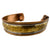 An antique gold-toned cuff bracelet featuring engraved sun and moon motifs, bordered by twisted rope detailing and a polished white inlay, shown against a plain white background.