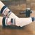 Person wearing pair of socks with text and checkered patterns on a white background. Text reads "With all due respect, fuck that."