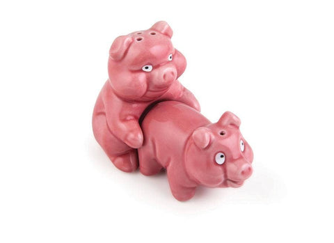 Two pink ceramic pigs in a suggestive position on a white background. 
