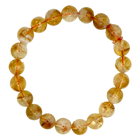 A beaded stretch bracelet made of round, translucent amber-yellow gemstone beads with natural inclusions, strung on a thin red cord, isolated on a white background.