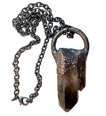 Necklace with a dark stone pendant and chain on a white background