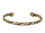 A twisted mixed metal cuff bracelet made in a rope-like pattern, set against a plain white background.