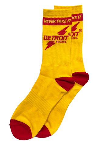 A pair of bright yellow crew socks with red toes, heels, and cuffs, featuring a red and yellow 'Detroit Original' logo with lightning bolts on the side.